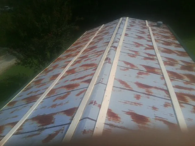 Rusted metal roof panels with new wood purlins before replacement — Storm Damage Roof Repair in Fostoria by Roofing Brothers